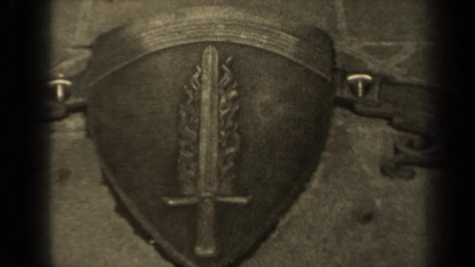 Close 1947 Paris 8mm view of a memorial shield emblem, with sword and flame-like shapes visible in the stone.