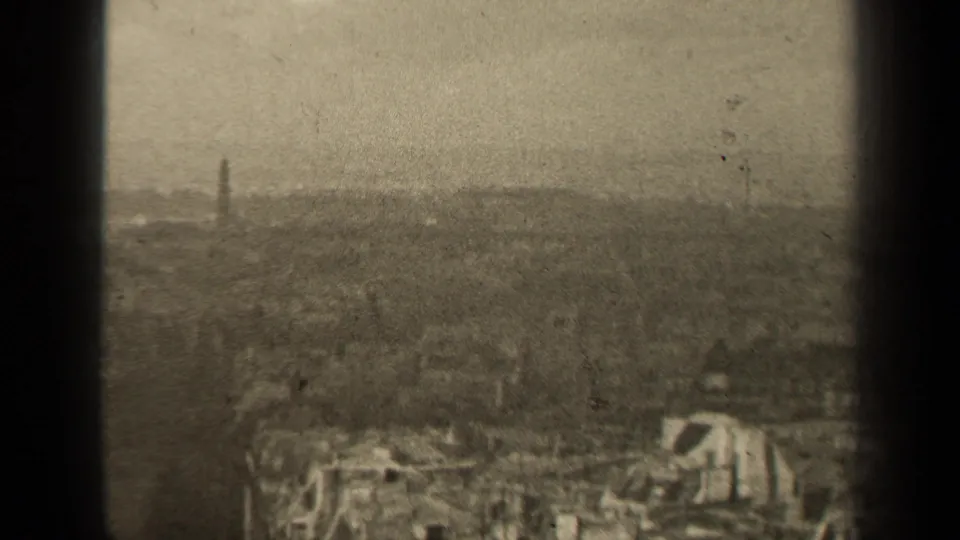 1947 Paris home-movie skyline frame with a blurred urban horizon, pale sky, and a slender tower at left distance.