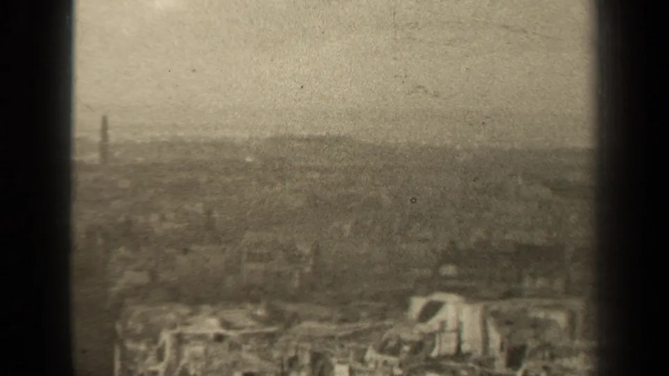 1947 Paris skyline frame showing a broad, hazy urban view with rooftops and a faint distant tower shape.
