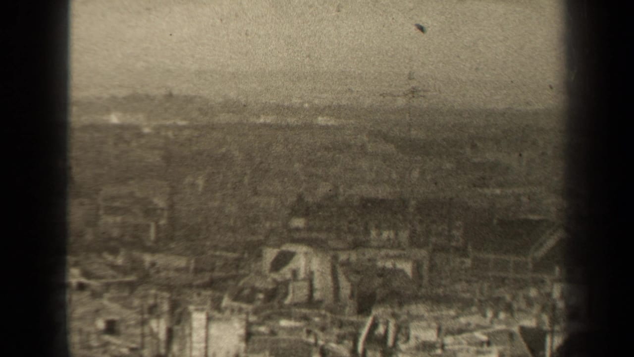 Damaged cityscape with low structures, debris, and a hazy horizon.