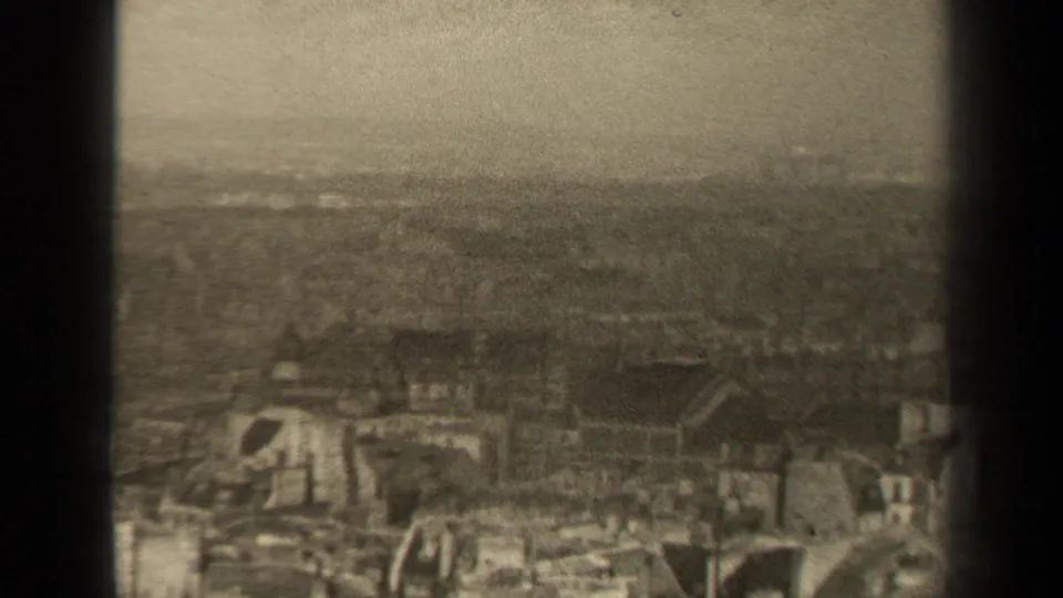 1947 Paris home-movie frame showing a hazy elevated view over dense rooftops and a muted horizon.