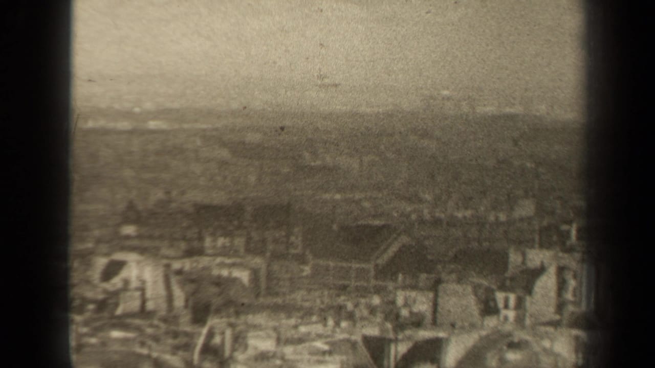 Soft city skyline and rooftops seen through haze with dark frame edges.
