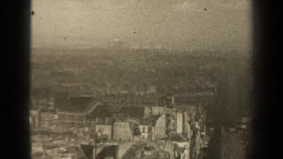 1947 Paris cityscape frame with dense old buildings and rooftops receding into haze, partially divided by dark foreground bars.