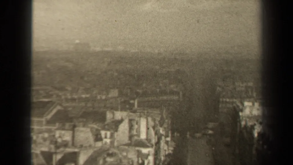 1947 Paris home-movie view of rooftops and light-toned old buildings fading into a hazy background behind dark foreground edges.