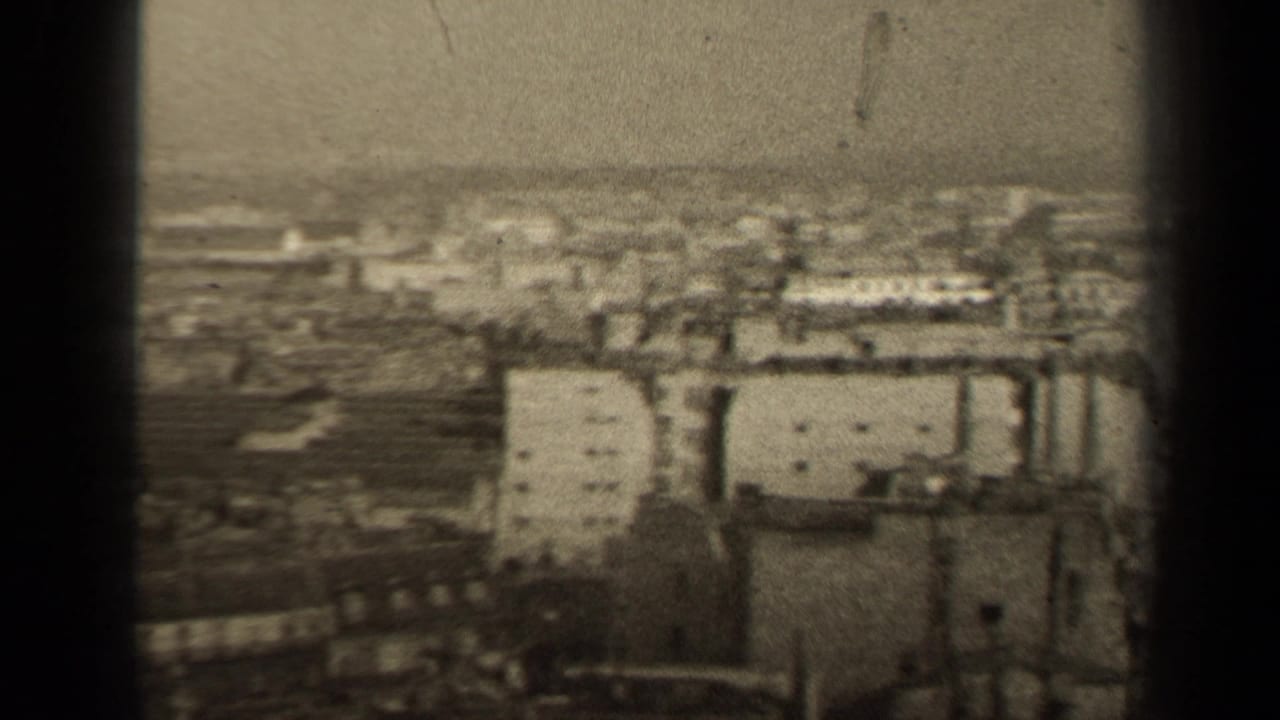 Grainy 1947 Paris city view with pale building facades, rooftops, and a hazy horizon.