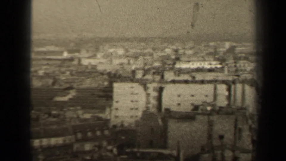 Grainy 1947 Paris city view with pale building facades, rooftops, and a hazy horizon.