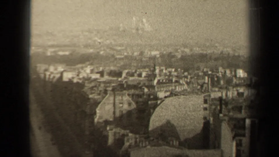 1947 Paris skyline view from above, with packed buildings, a rounded dome-like structure, distant vertical landmarks, and visible film grain.