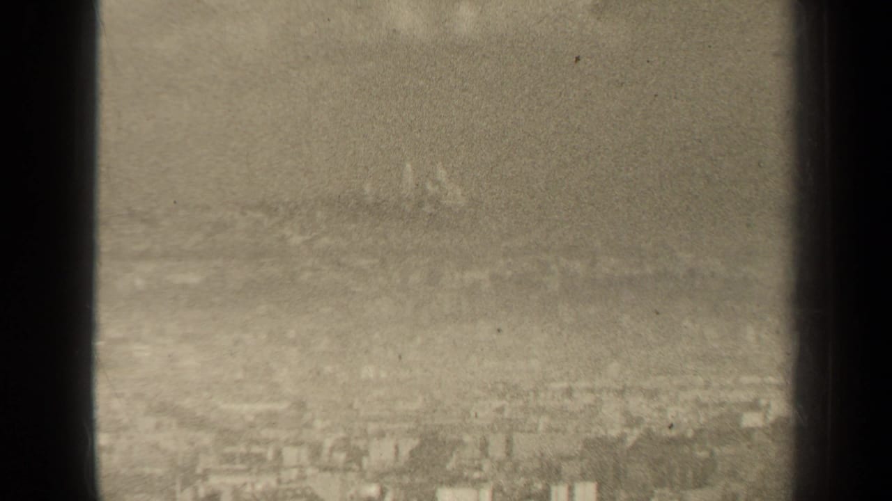 Soft, hazy city skyline with faint distant buildings and dark edge framing.