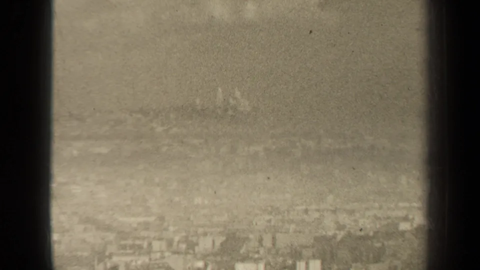 A muted 1947 Paris skyline appears through haze, with low buildings fading into the distance.