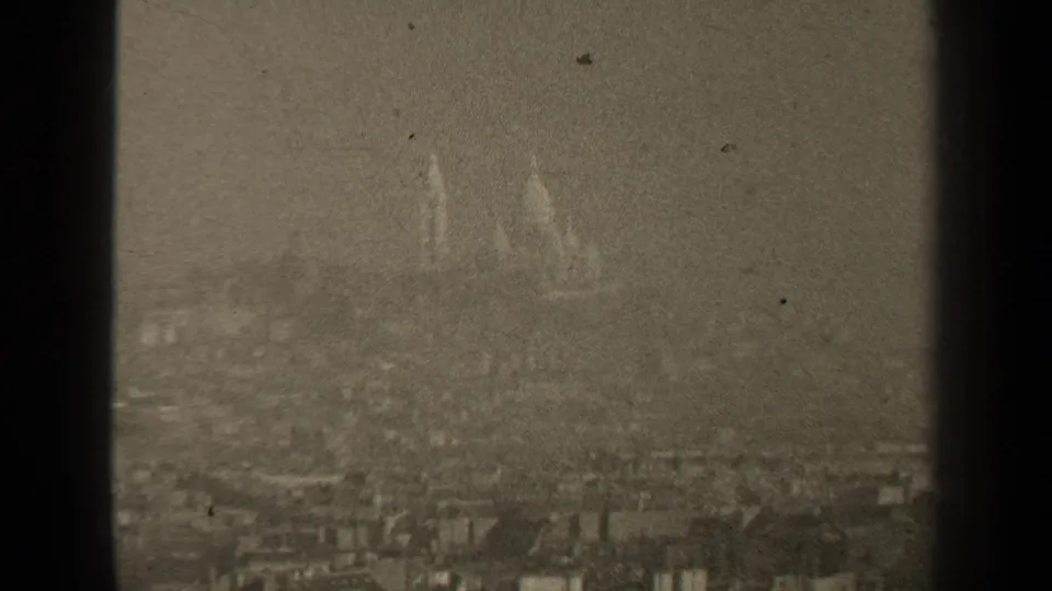 The final 1947 Paris frame holds on a distant church or cathedral form above a grainy urban panorama.