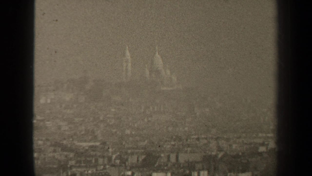 Hazy distant city skyline with faint domes and dark film borders.