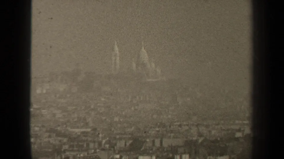 1947 Paris 8mm frame showing a distant, hazy skyline with faint domed architecture and heavy film grain.