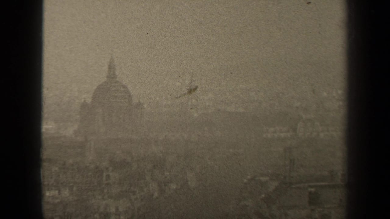 Hazy skyline with a domed building seen through dark 8mm frame edges.