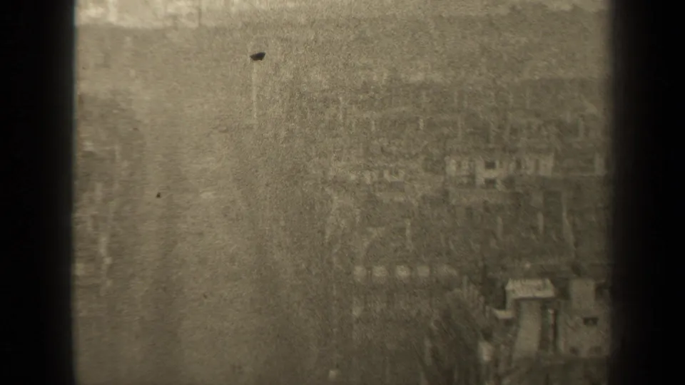 Soft 1947 Paris urban view with distant buildings, street details, bare branches, dust specks, and dark window-frame edges.