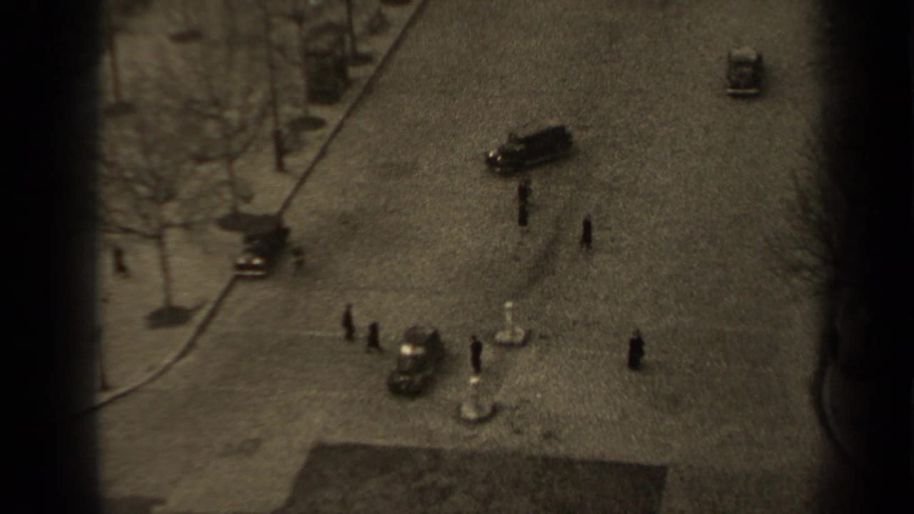 Elevated 1947 Paris street scene showing pedestrians crossing near vintage cars, bare trees, and a curved curb line.