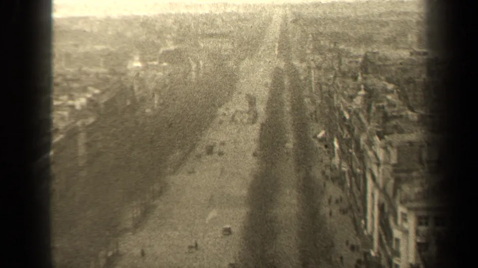 Grainy 8mm view of a Paris boulevard in 1947, showing pedestrians, a few cars, building rows, and uneven exposure.
