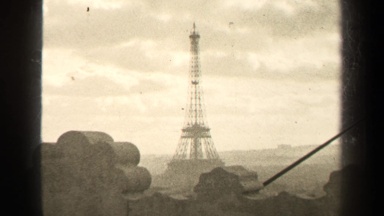 Eiffel Tower centered in a hazy skyline with dark vertical framing and a diagonal rod.