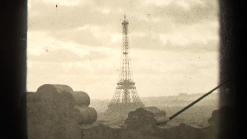 Distant 1947 Paris view of the Eiffel Tower framed by dark window edges, foreground stone shapes, and a cloudy sky.