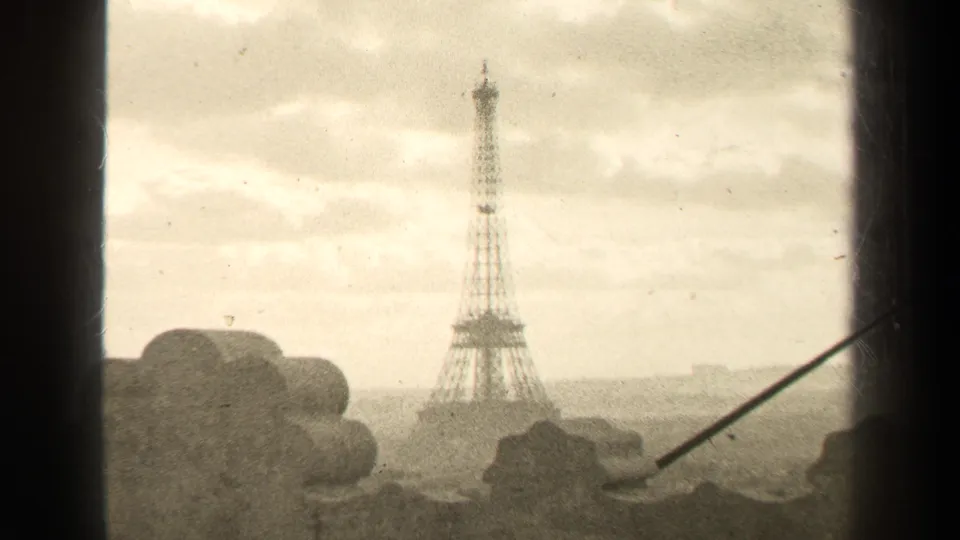 Final 1947 Paris frame showing the Eiffel Tower in the distance, partly framed by a dark edge and a thin diagonal line.