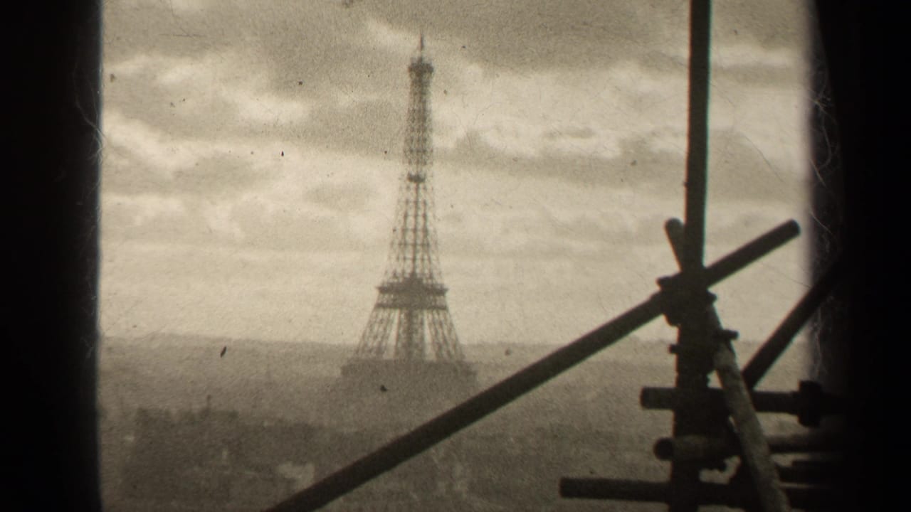 1947 Paris home-movie frame showing the Eiffel Tower beyond a hazy skyline, viewed through dark window framing and scaffolding.