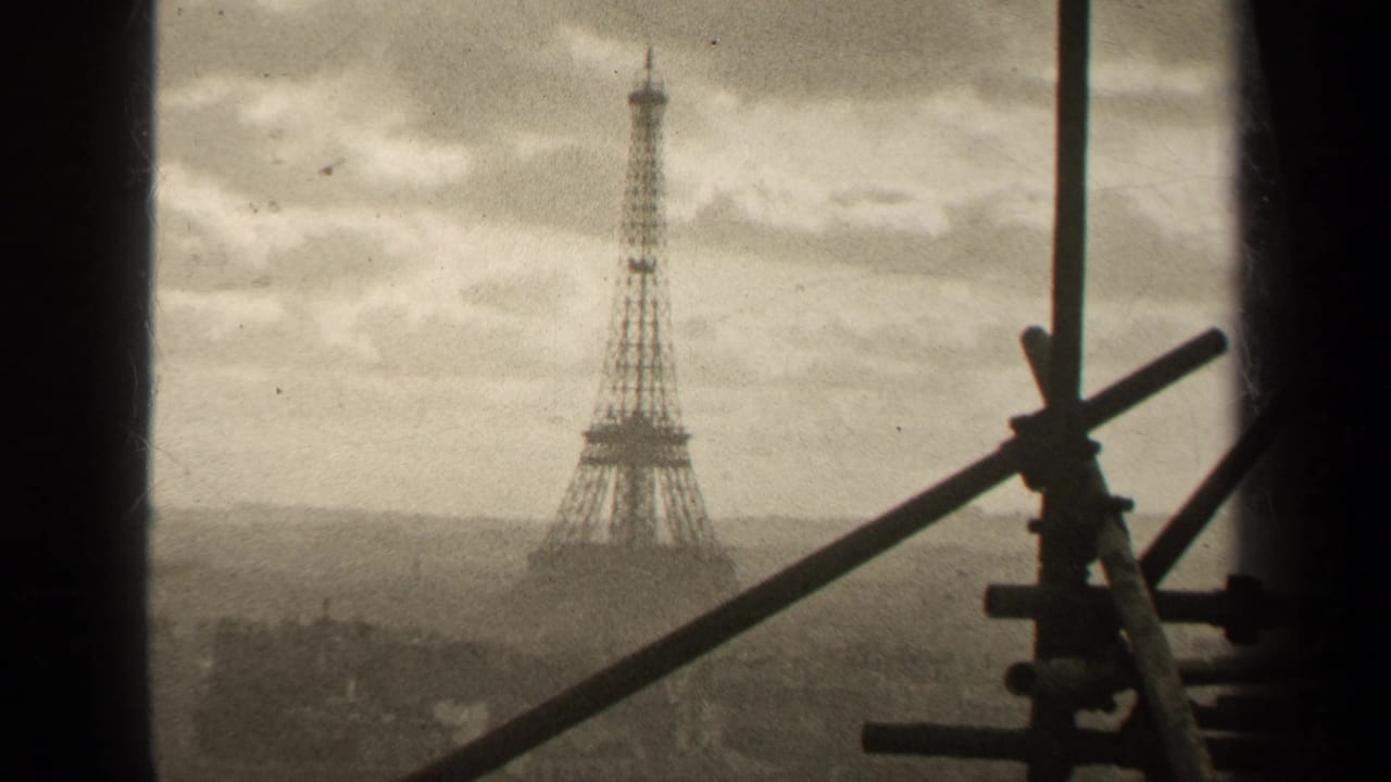 Distant Eiffel Tower framed by scaffolding and dark vertical edges.