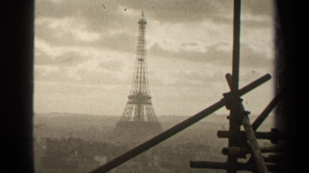 Eiffel Tower seen through dark window edges with scaffolding and pipes in the foreground.