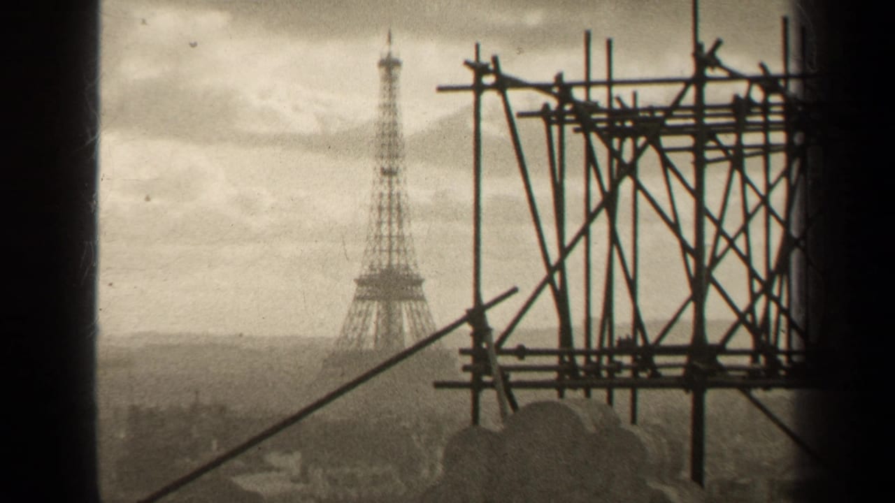 1947 Paris home-movie frame showing the Eiffel Tower in the distance behind silhouetted scaffolding and a hazy skyline.
