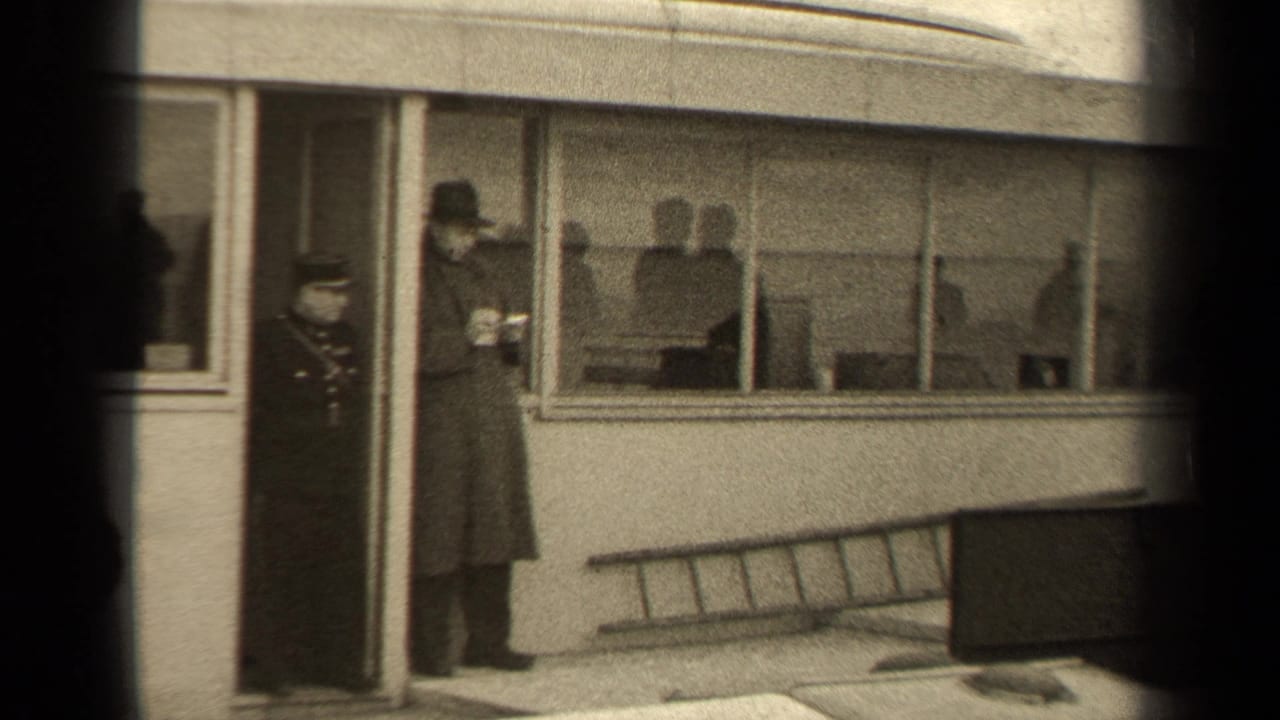 Civilian in a long coat stands near the windowed building while a uniformed figure remains by the doorway.