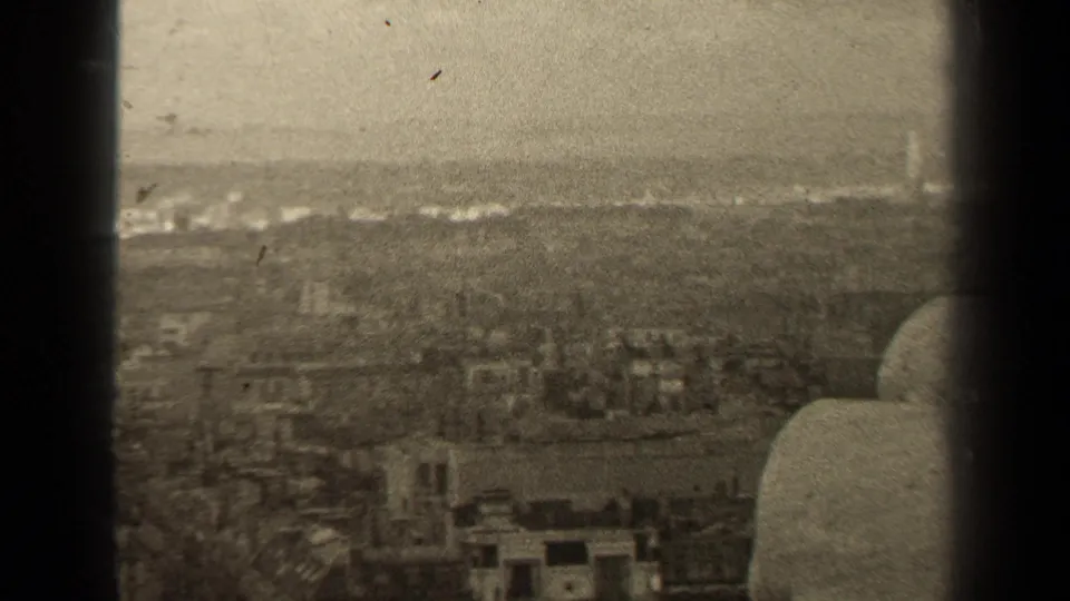 From a high Paris vantage point, the frame looks across rooftops and haze toward a distant horizon in 1947 home-movie footage.