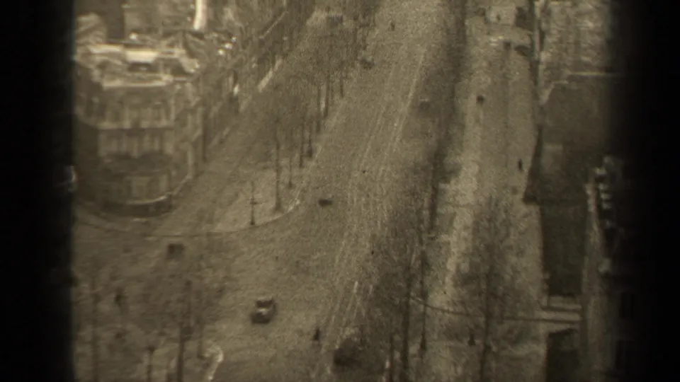 Elevated 1947 Paris street view showing a broad boulevard, sparse automobile traffic, pedestrians, street trees and multi-story urban buildings.