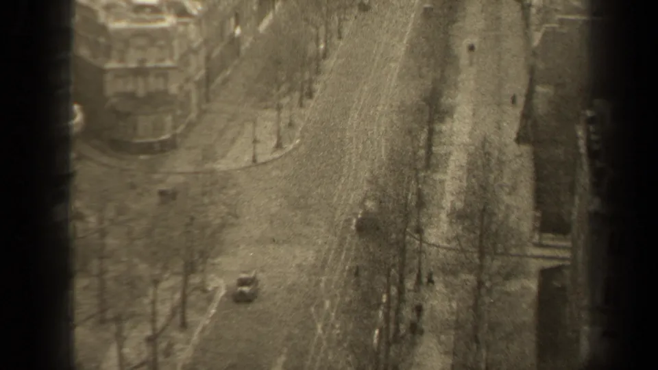 Elevated Paris street view from 1947 showing a single car, bare trees, sidewalks, and small pedestrian figures.