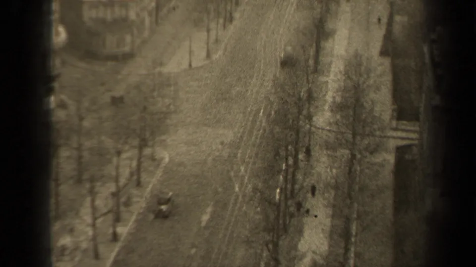 Final 1947 Paris street view from above, showing bare trees, scattered pedestrians, a small car, and soft 8mm texture.