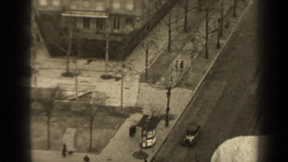 The 1947 Paris street scene includes pedestrians on sidewalks, a small kiosk near the curb, bare trees, and vintage cars.