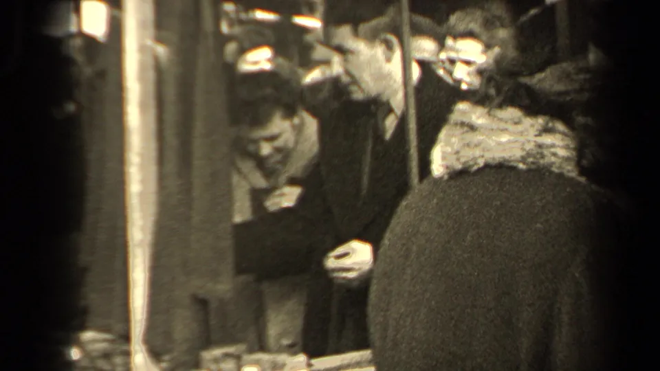 1947 Paris transit scene with bundled passengers in overcoats standing tightly together near metal poles.