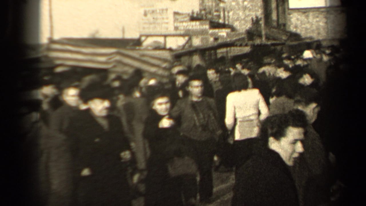 1947 Paris crowd scene showing people in coats and hats passing near market-style awnings, with several visible faces and bags.