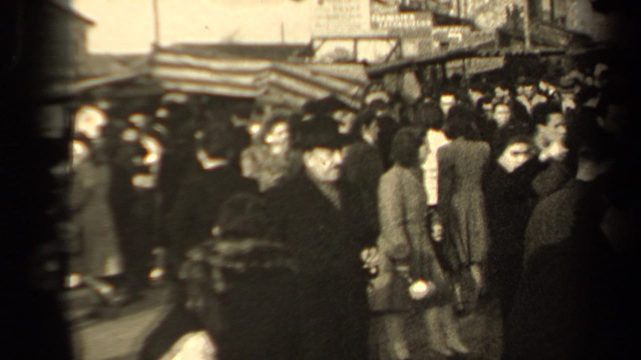 Paris street crowd in 1947 with pedestrians in heavy coats and hats moving through a dense public market or shopping area.
