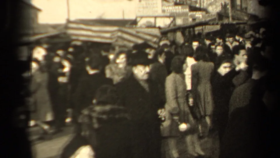 Paris street crowd in 1947 with pedestrians in heavy coats and hats moving through a dense public market or shopping area.