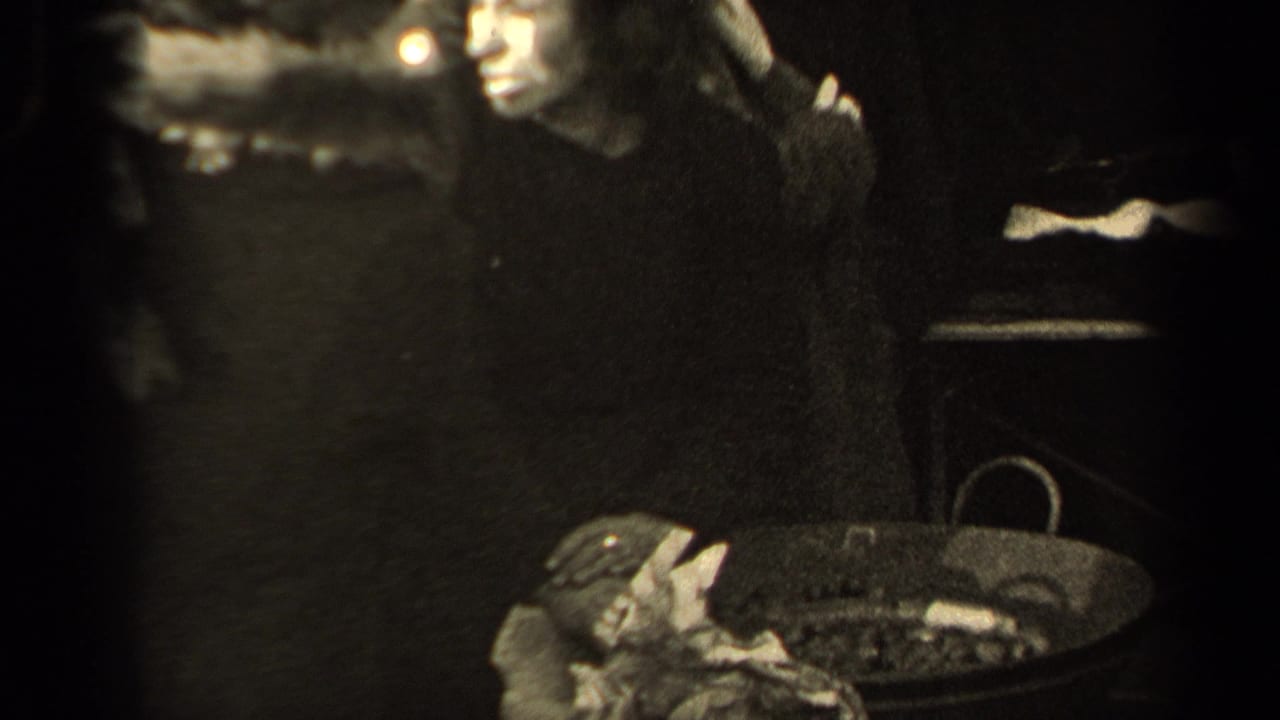 Woman reaches toward items in a basket while standing in a crowd.