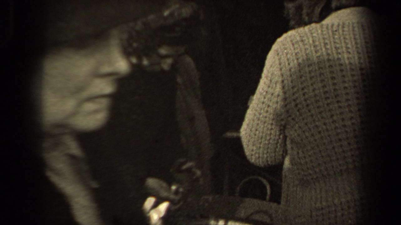 A blurred passerby crosses the foreground while a woman in a knit sweater stands near the basket in the Paris street crowd.