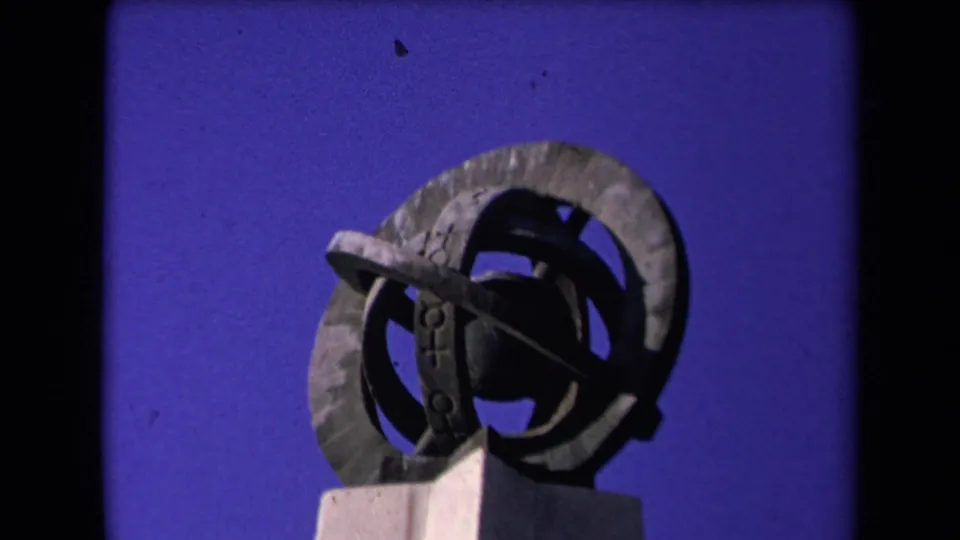1967 Los Angeles frame of a weathered circular metal sculpture, seen from below on a light pedestal.