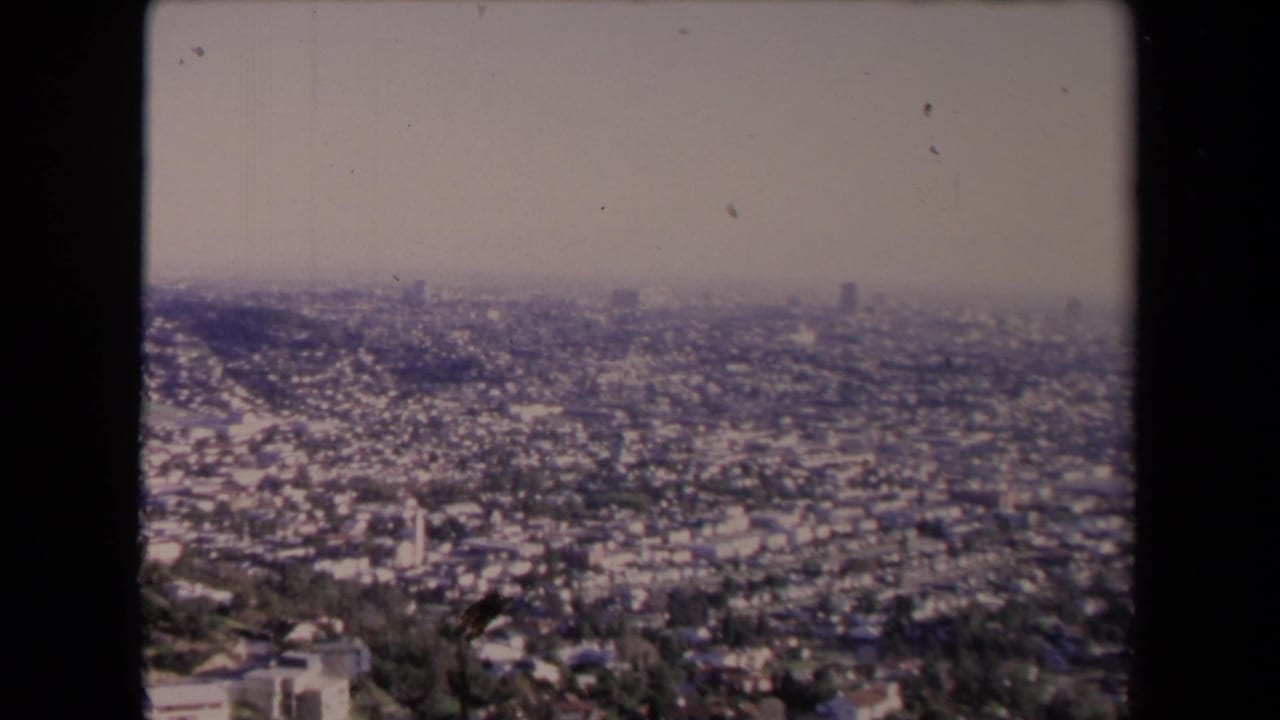 Hazy distant view over Los Angeles neighborhoods from an elevated vantage point.