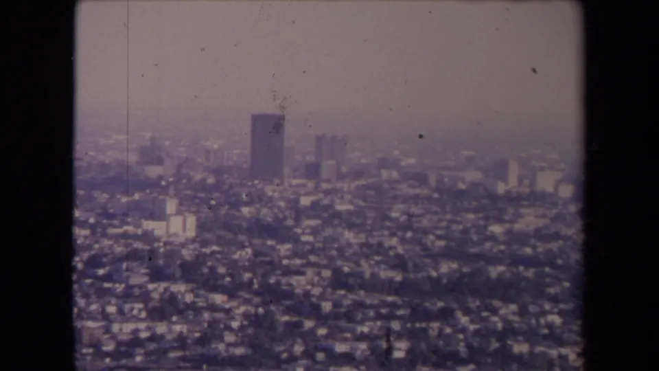 1967 Los Angeles aerial view showing dense neighborhoods, distant towers, and heavy haze across the city.