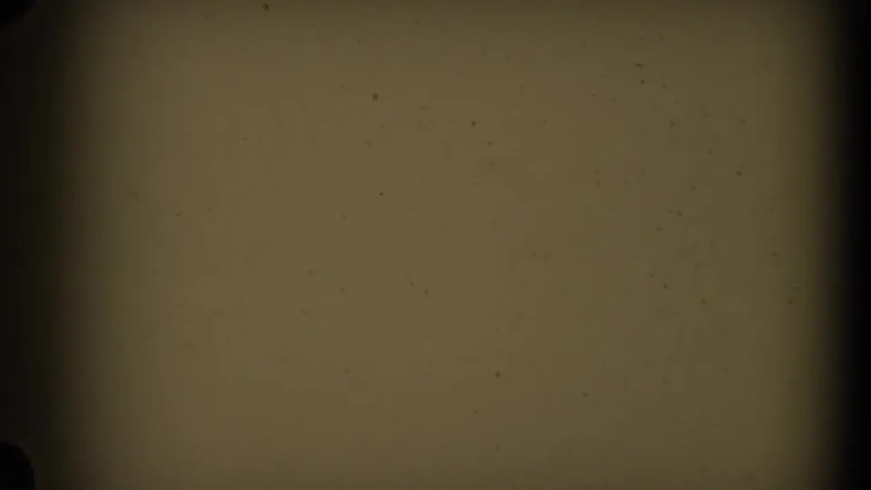 A transitional 8mm frame with blank yellowed exposure, dark gate edges, and visible dust specks.