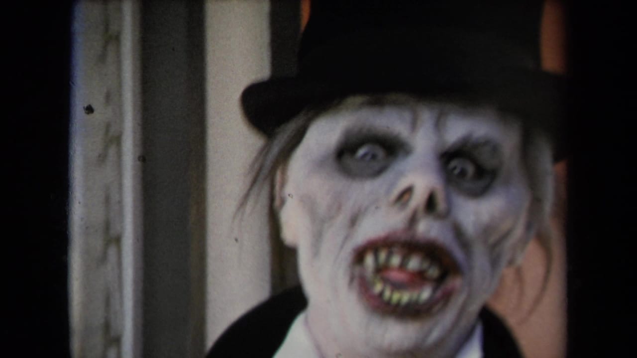 Close 8mm frame of a ghoul-like face in dark eye makeup, sharp-looking teeth, and a black top hat, supported by 1967 Los Angeles metadata.