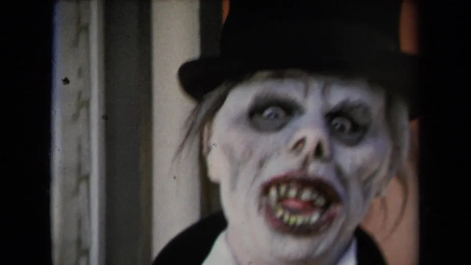 Close 8mm frame of a ghoul-like face in dark eye makeup, sharp-looking teeth, and a black top hat, supported by 1967 Los Angeles metadata.