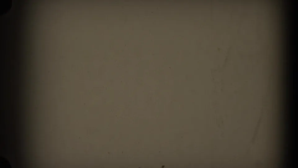 A second mostly obscured 8mm frame showing film texture, dark edge shadows, and limited visible scene detail.
