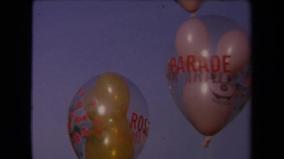 A Mickey-shaped balloon and clear printed balloon appear together against the sky in 1967 Los Angeles footage.