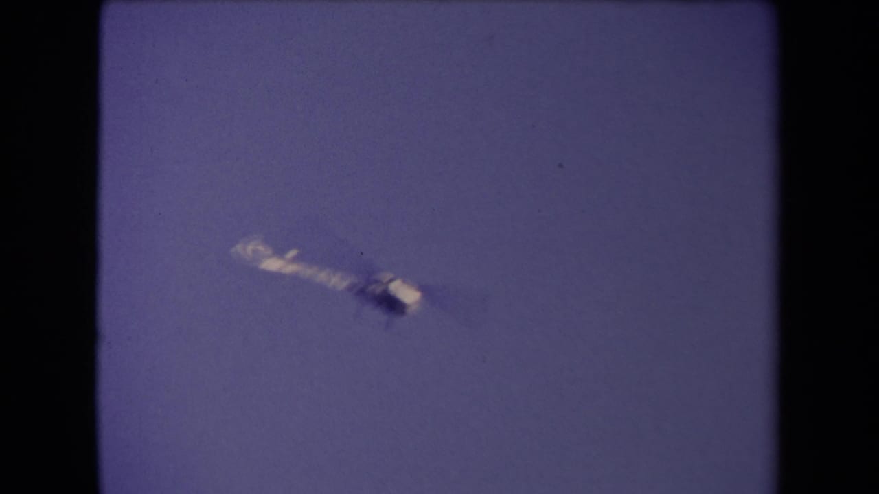 A small aircraft or helicopter appears against the sky in 1967 Los Angeles home-movie footage.