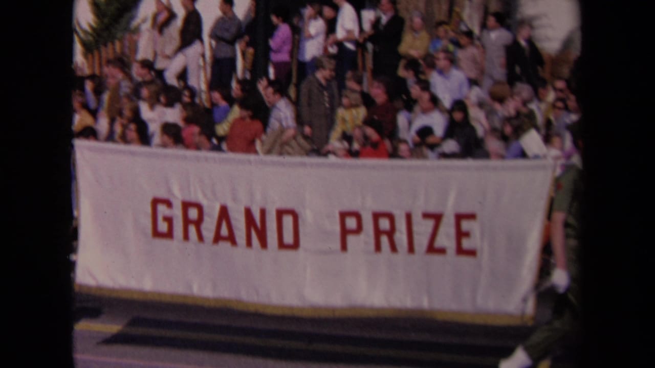 1967 Los Angeles parade view with spectators gathered above a large white GRAND PRIZE banner in red letters.
