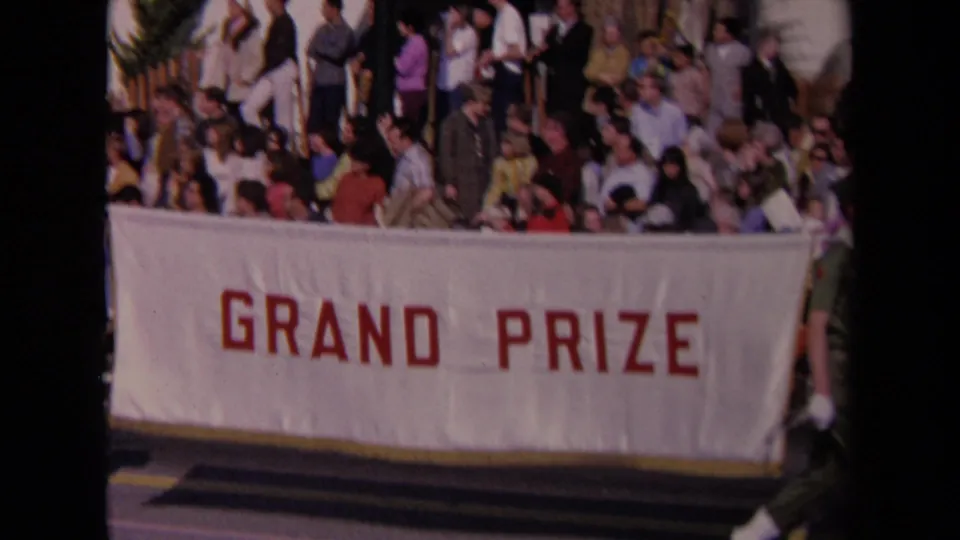 1967 Los Angeles parade view with spectators gathered above a large white GRAND PRIZE banner in red letters.